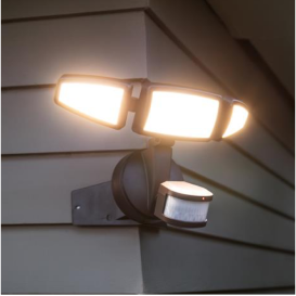 A motion-sensor light mounted on the corner of a house.