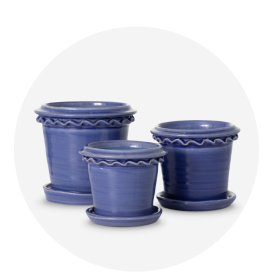 A set of 3 blue ceramic planters with attached saucers.