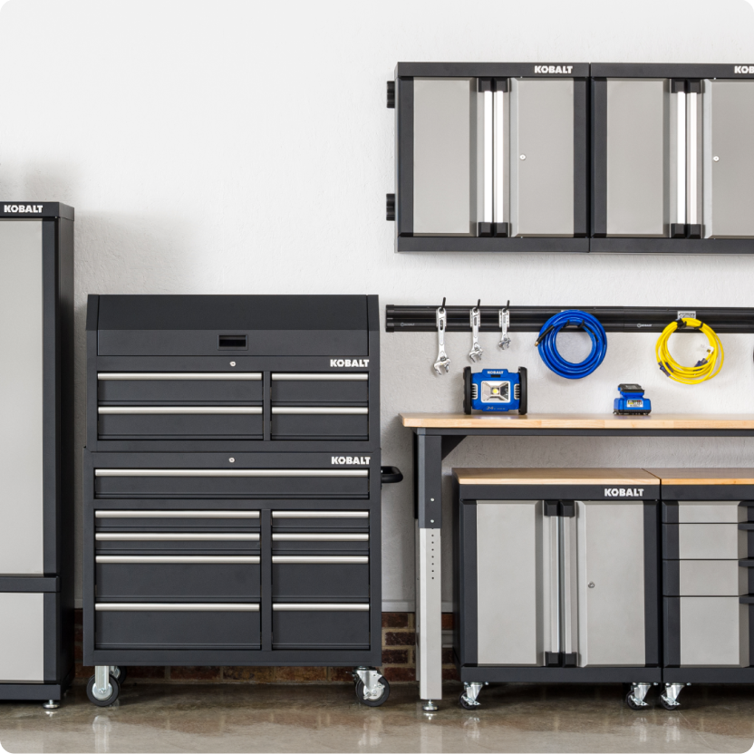A garage organized with Kobalt storage shelf, cabinets, tool chest and rail system.