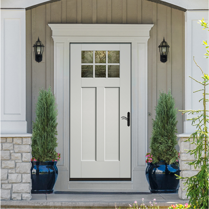 A white craftsman-style quarter-lite single front door on a house with gray board and batten siding.