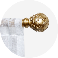 A sheer white curtain hanging from a gold curtain rod.