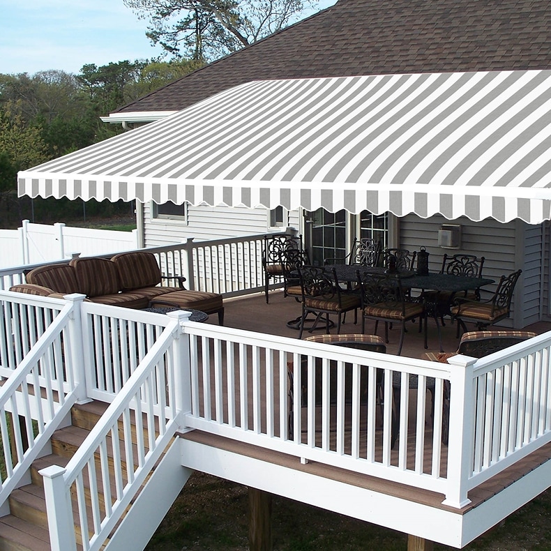 A deck with white railings covered by a gray and white striped awning.