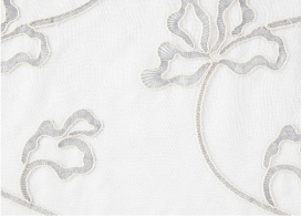 A close-up of a white curtain with a gray floral design.