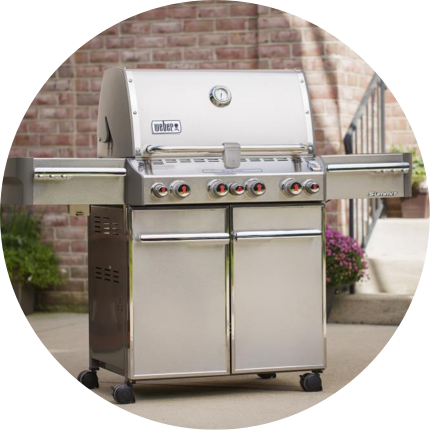 A stainless Weber Summit Grill on a patio.