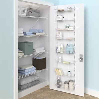 A linen closet with neatly folded towels and blankets and white wire over-the-door storage shelves.