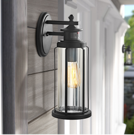 A black outdoor motion-sensor wall light with clear glass shade.