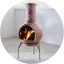 A clay chiminea on a black metal stand.