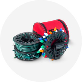 Two sets of Christmas lights wrapped around light storage reels and a red storage bag.