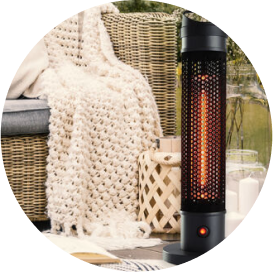 A small black electric patio heater next to a wicker outdoor couch.