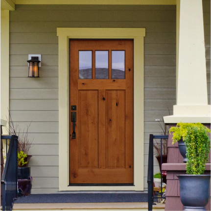 A front porch with a wood craftsman-style front door with a three-lite window at the top.