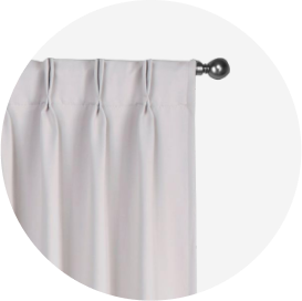 A white pinch pleat style curtain on a chrome rod.