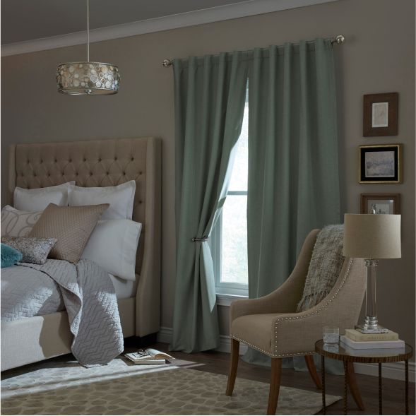 A bedroom with light blue room darkening curtains on the window.