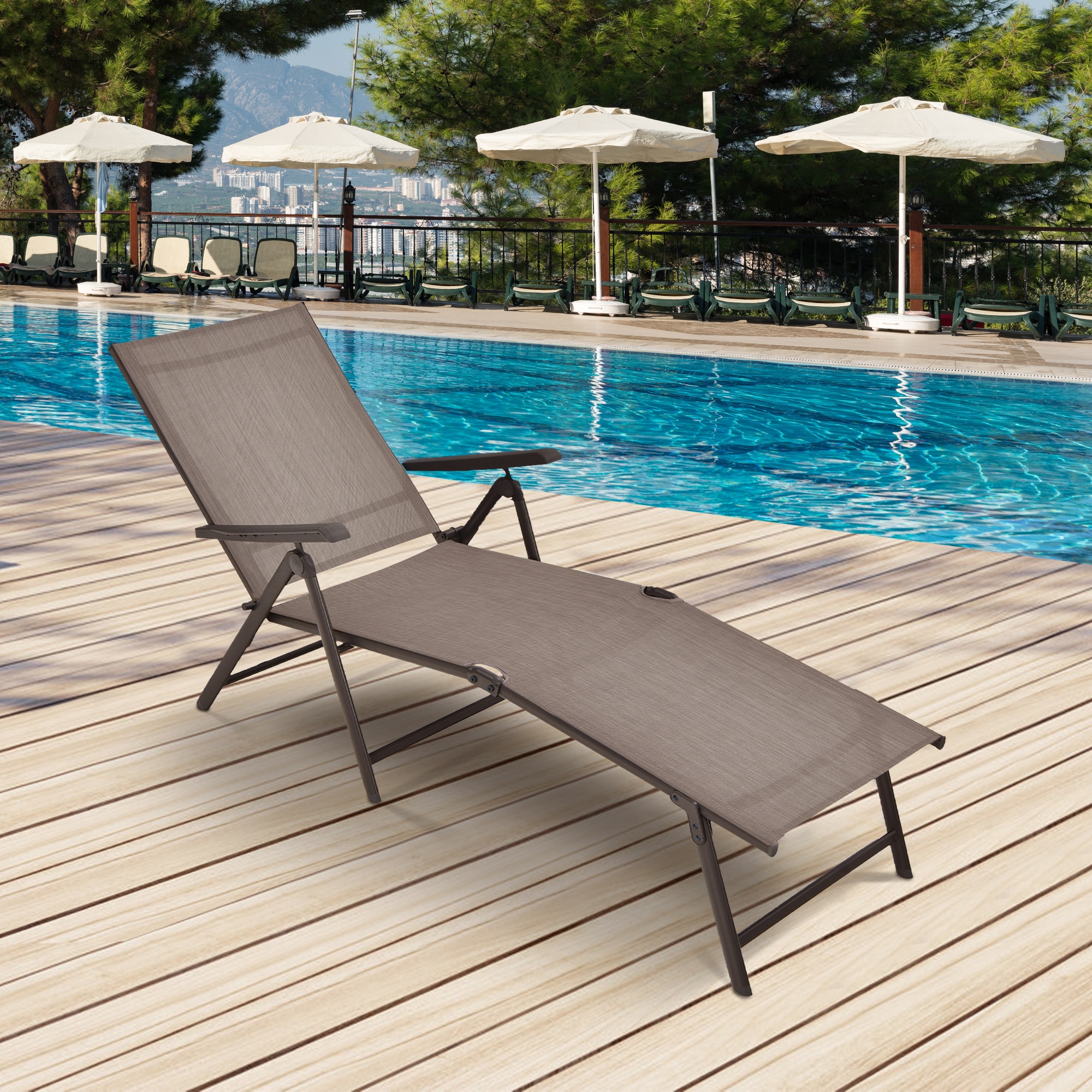 Chaise lounge on pool deck with umbrellas and city backdrop