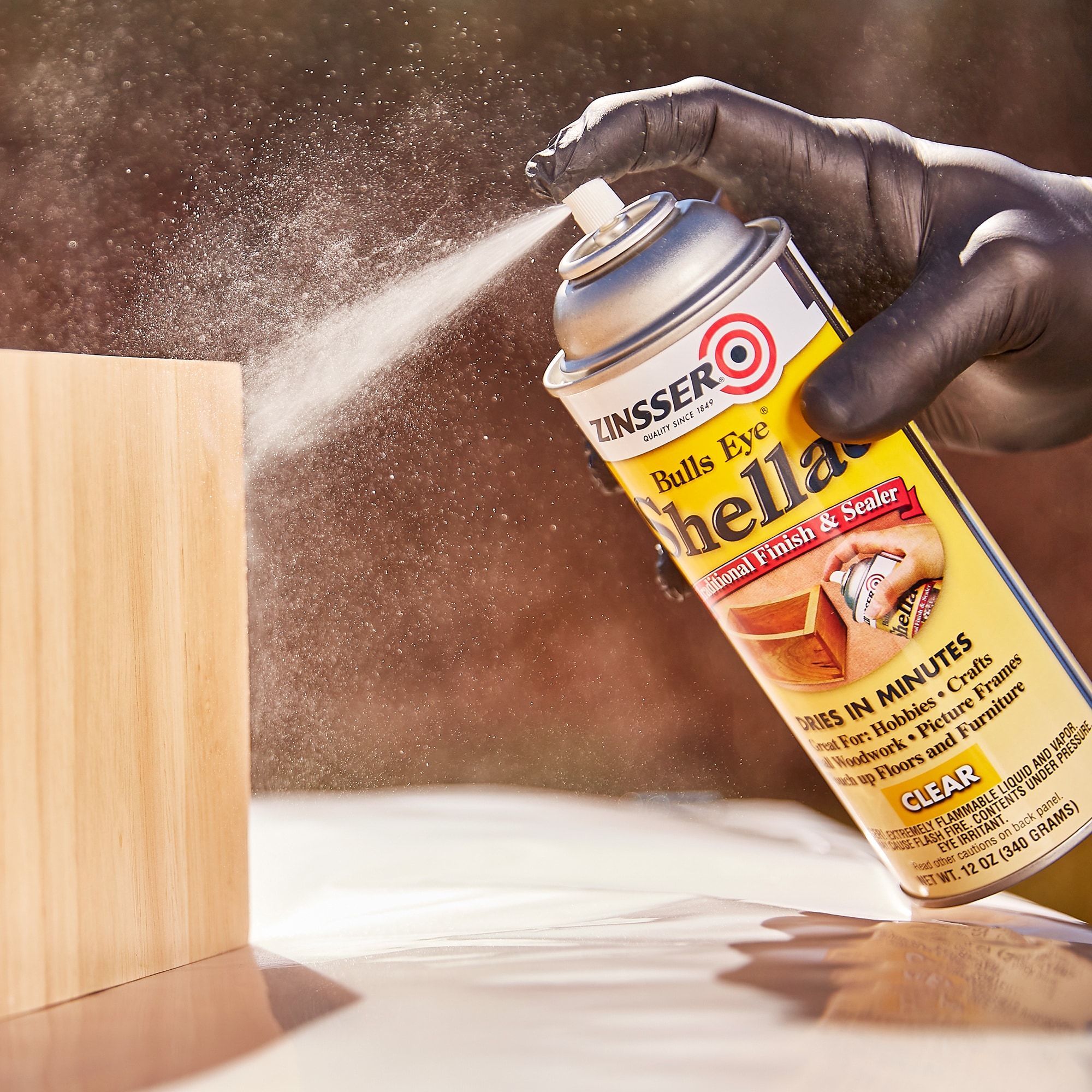 Spray shellac inexpensively, and caveman simple, and perfectly. A $10  sprayer. 