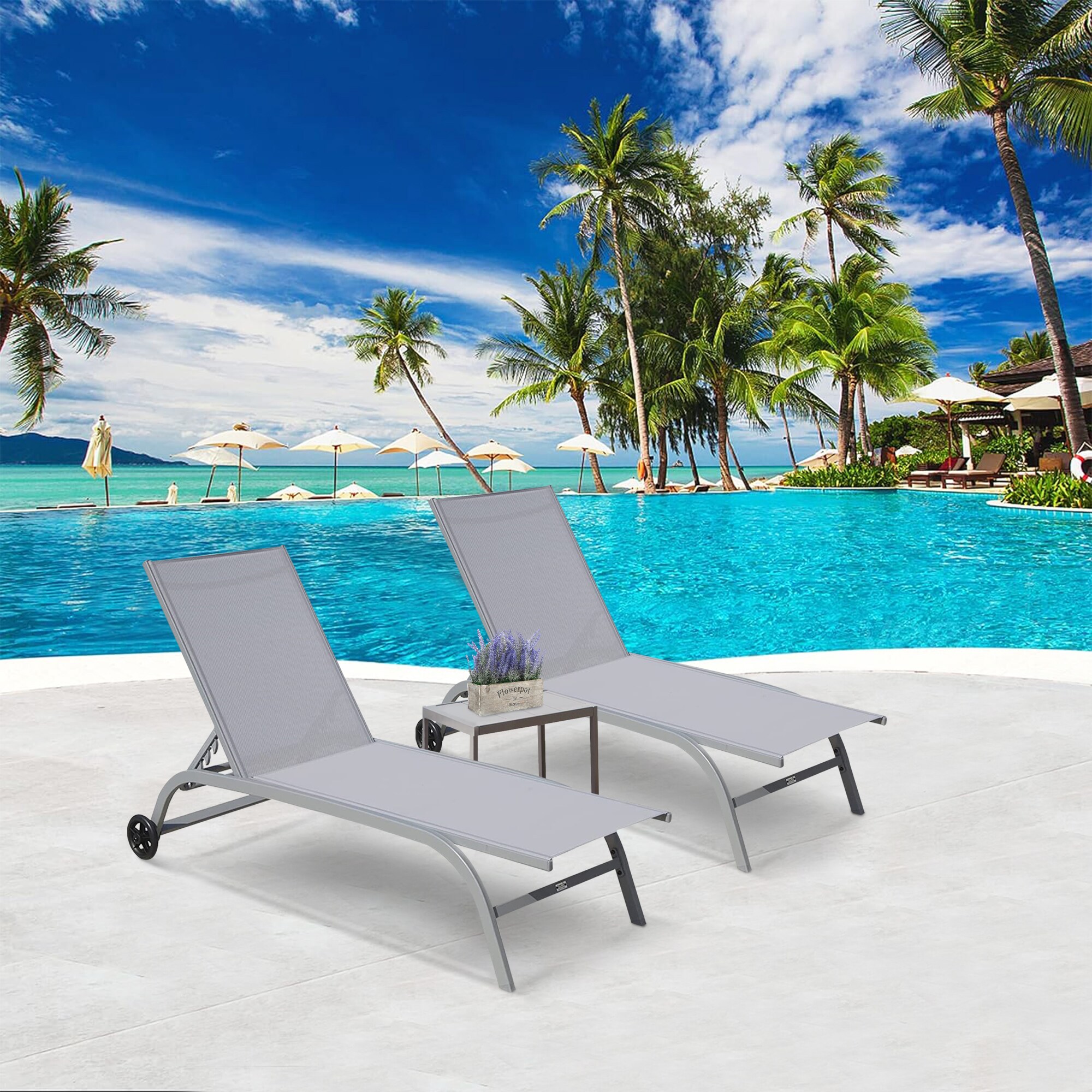Two grey chaise lounges by pool on deck under blue sky