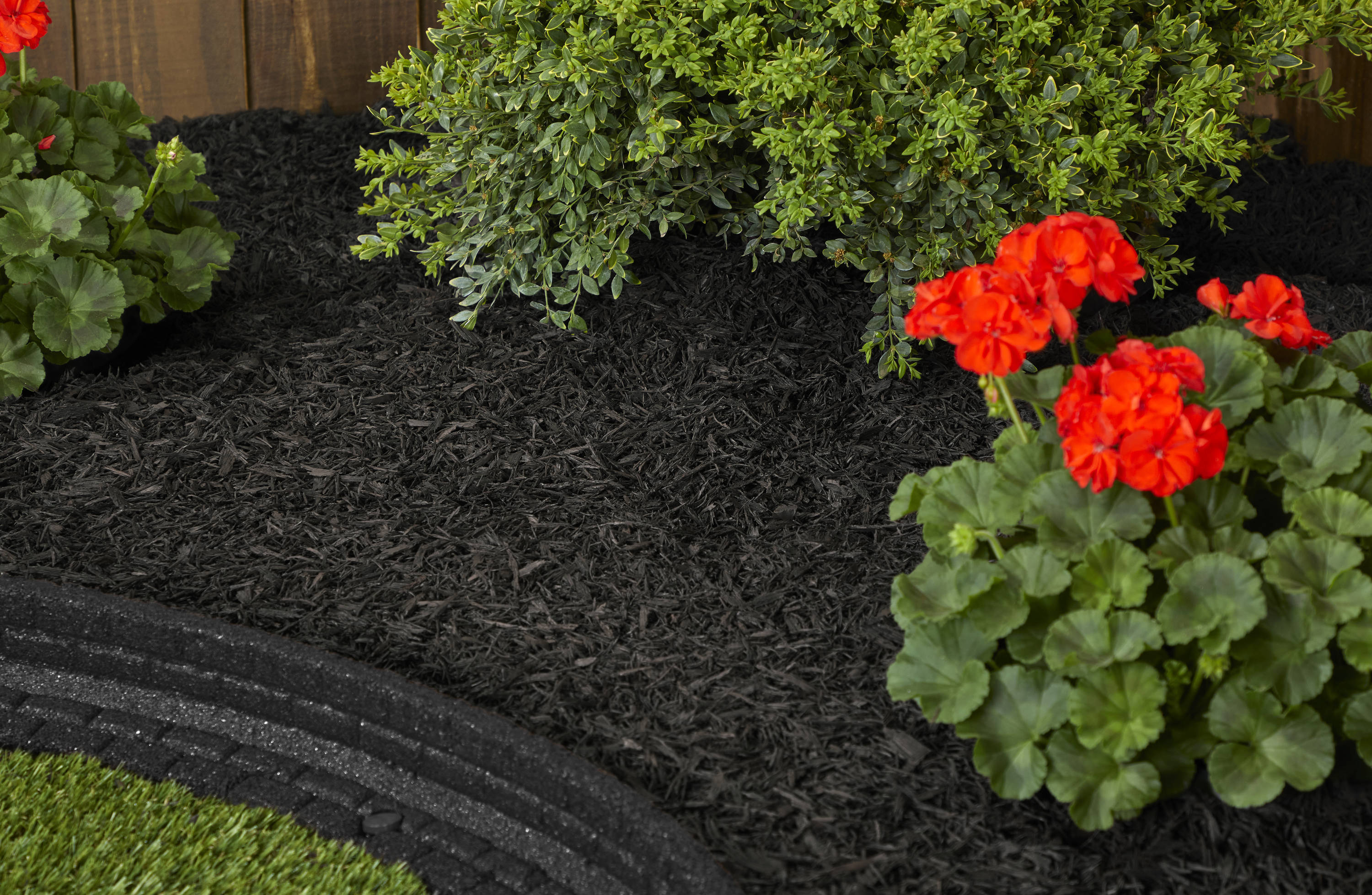 Image of Landscaper spreading black rubber mulch