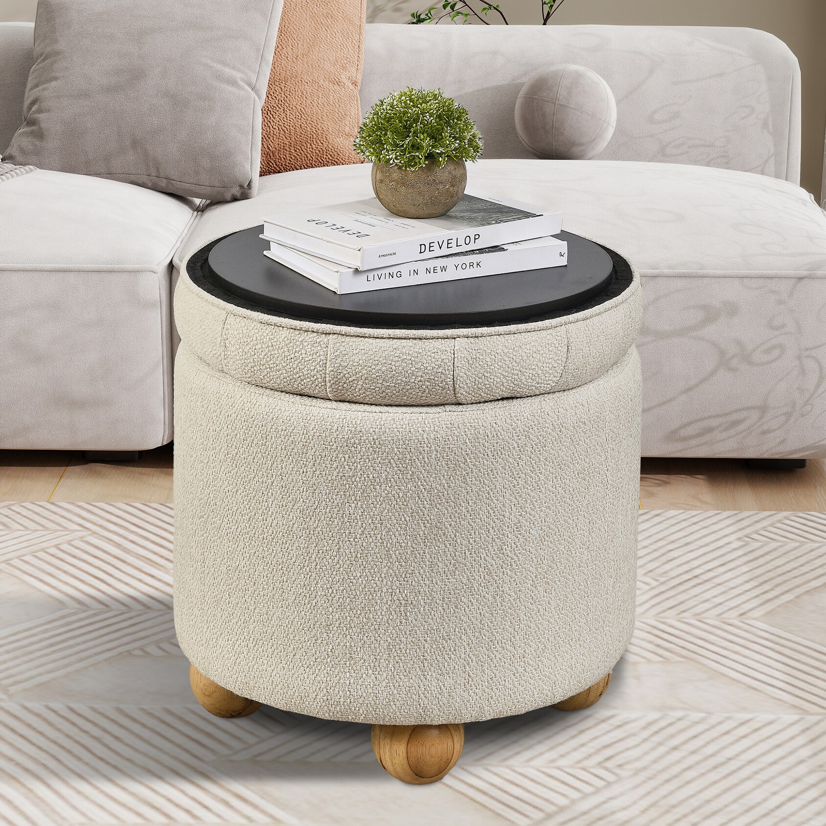 Round beige storage ottoman functioning as a coffee-table-like ottoman